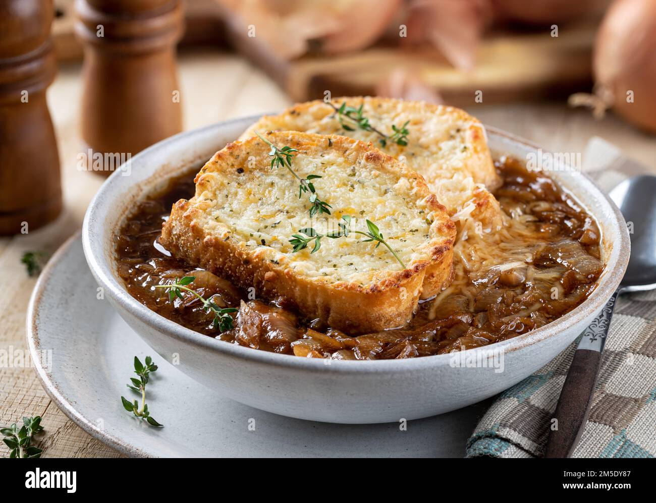 French onion soup with toasted cheese baguette garnished with thyme on