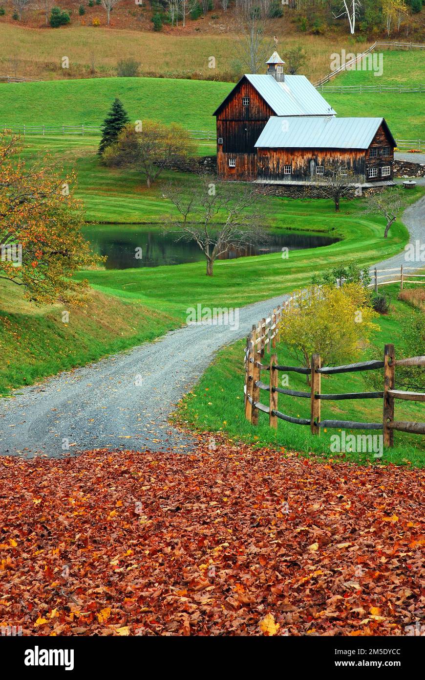 A winding country lane leads to a bucolic farm in Vermont during the New England autumn Stock Photo