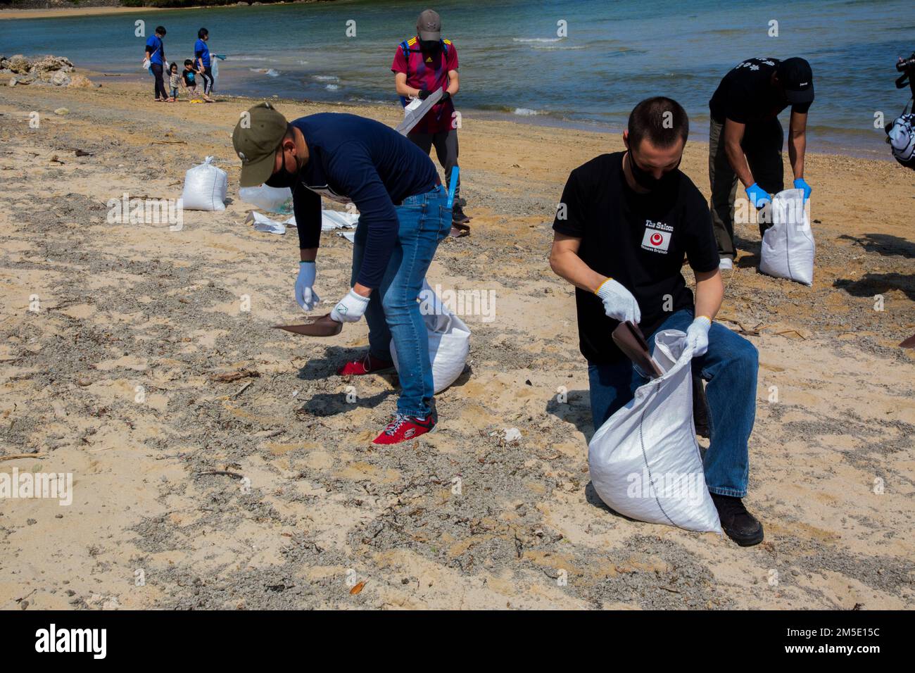 Marines use a dustpan to separate pumice from the sand. Stock Photo