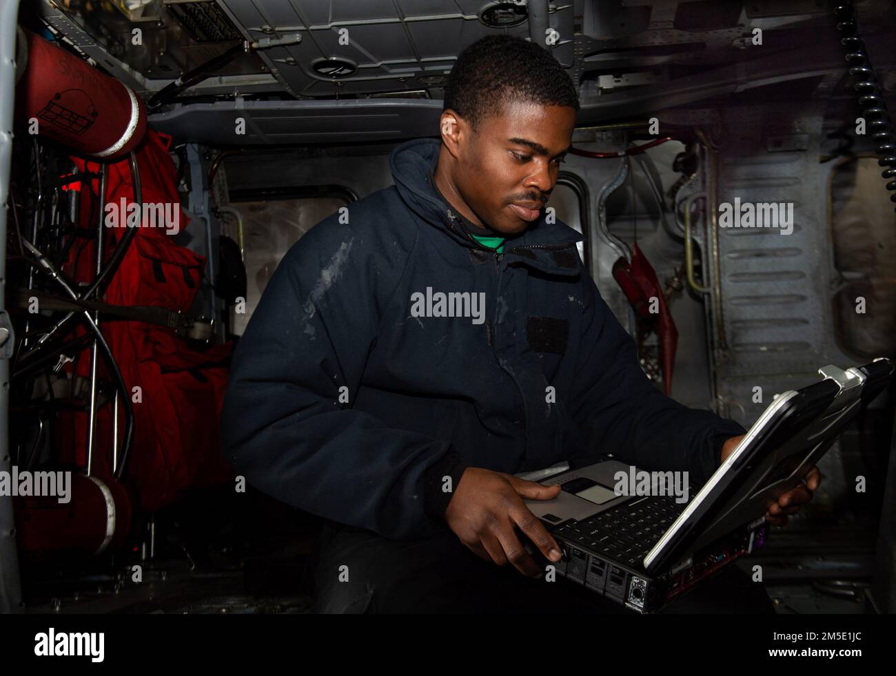 220306-N-CY569-1038 AEGEAN SEA (Mar. 6, 2022) Aviation Structural Mechanic 2nd Class Godwin Afenu, from Dumfries, Virginia, assigned to the 'Dragonslayers' of Helicopter Sea Combat Squadron (HSC) 11, inspects the landing gear pressure of an MH-60S Sea Hawk helicopter in the hanger bay of the Nimitz-class aircraft carrier USS Harry S. Truman (CVN 75), Mar. 6, 2022. The Harry S. Truman Carrier Strike Group is on a scheduled deployment in the U.S. Sixth Fleet area of operations in support of U.S., allied and partner interests in Europe and Africa. Stock Photo