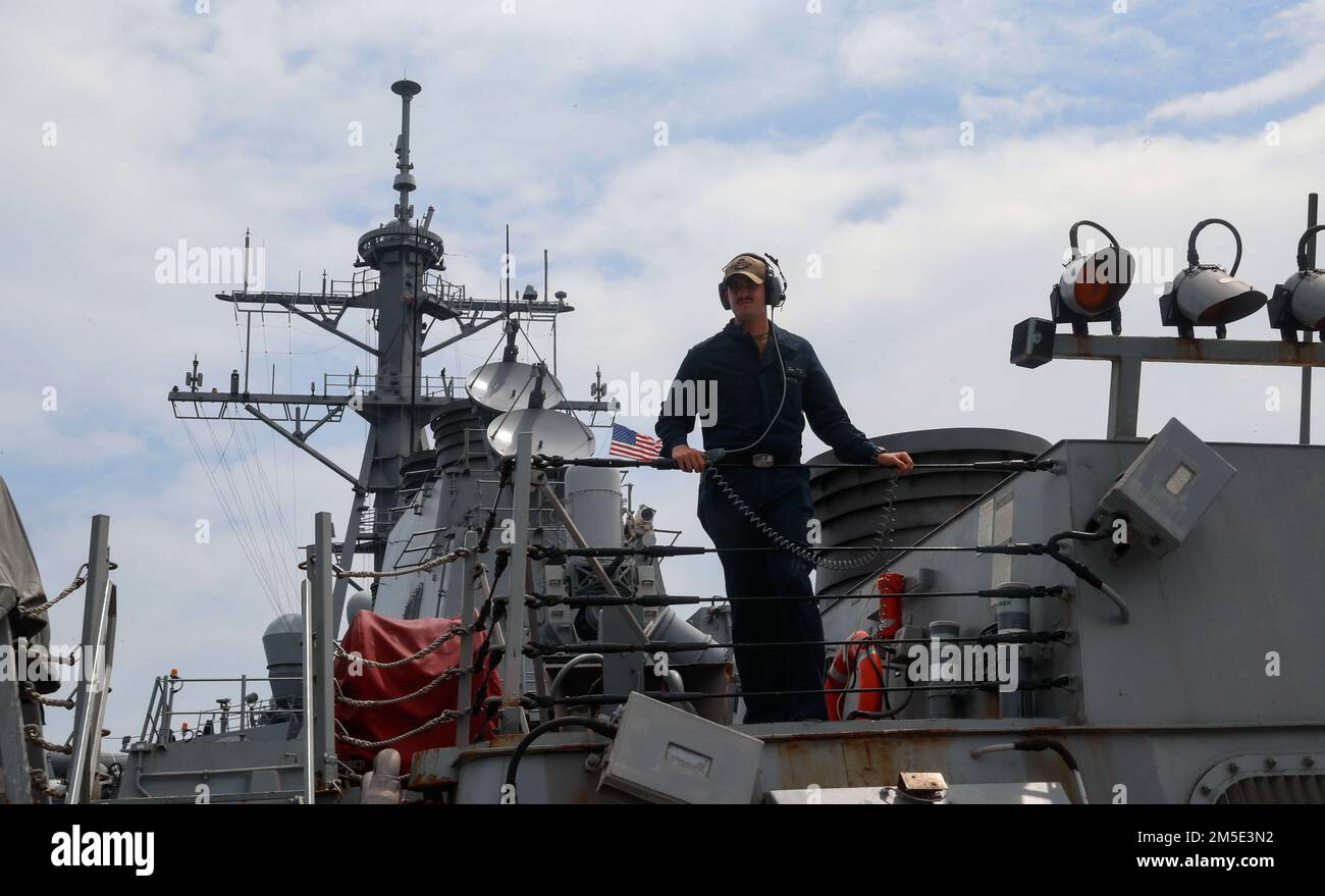 INDIAN OCEAN (March 6, 2022) Boatswain’s Mate Seaman Anthony Dyer, from Baltimore, Md., stands aft lookout watch on the missile deck of the Arleigh Burke-class guided-missile destroyer USS Fitzgerald (DDG 62). Fitzgerald is on a scheduled deployment in the U.S. 7th Fleet area of operations to enhance interoperability with alliances and partnerships while serving as a ready-response force in support of a free and open Indo-Pacific region. Stock Photo