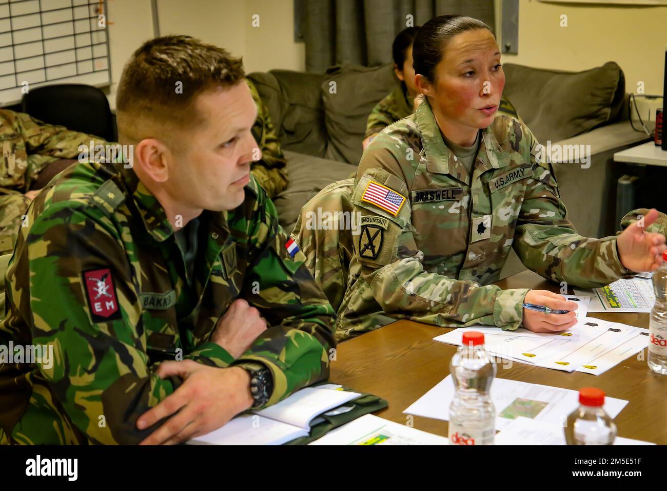 MIHAIL KOGALNICEANU AIR BASE, Romania – Lt. Col. Braswell, commander of 3rd Battalion, 227th Aviation Regiment and Maj. Bakker of the Royal Netherlands 11th Air Assault Brigade discuss sling load and air assault planning during Rapid Falcon, MK Air Base, Romania, March 6, 2022.    Rapid Falcon is designed as a joint multinational exercise to increase operability and joint reaction capacity as well as the development of functional relationships between participating structures. Stock Photo