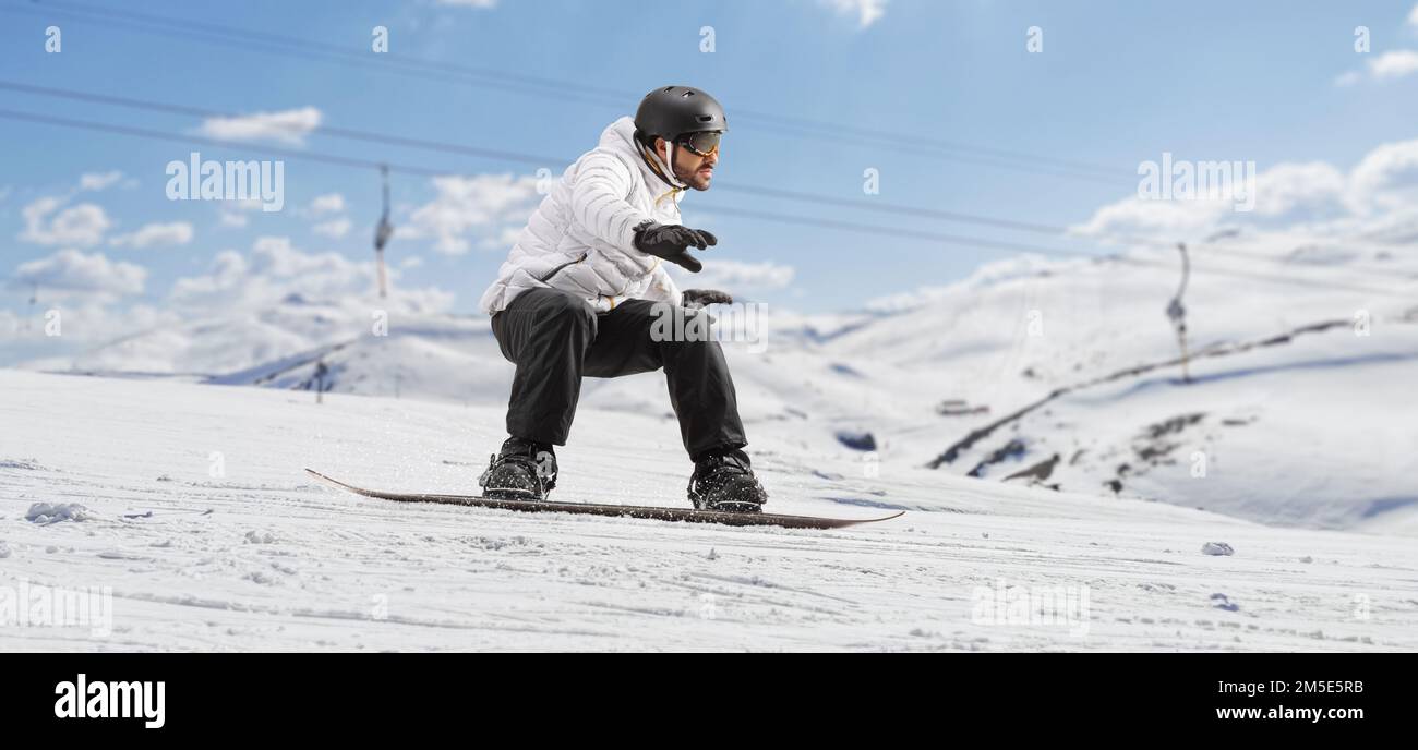 Snowboarder riding a snowboard at a ski resort Stock Photo