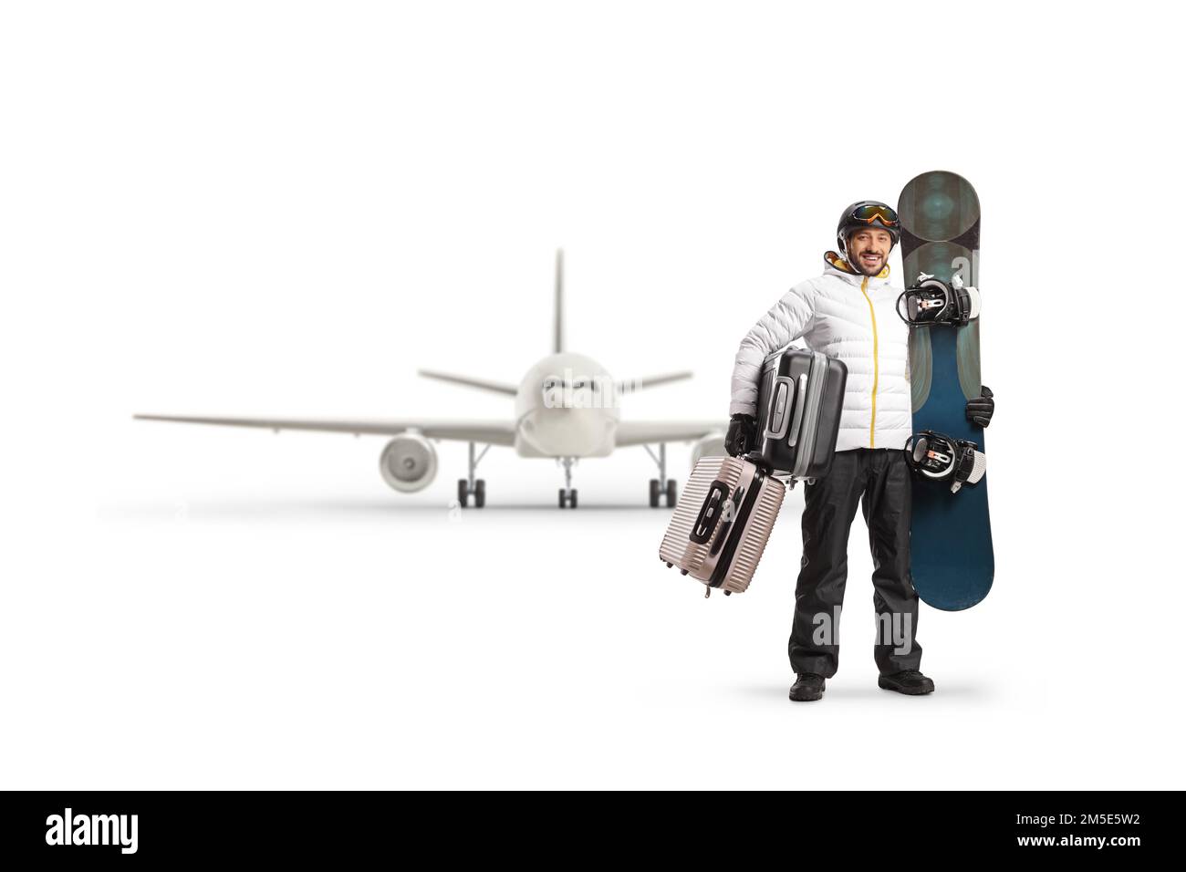 Full length portrait of a man with a snowboard and suitcases waiting for a flight isolated on white background Stock Photo