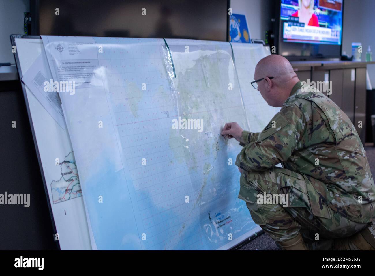 Sgt. 1st Class Niles Serls, with Headquarters and Headquarters Company, 60th Troop Command, North Carolina National Guard, plots points on a map during Exercise Arctic Eagle-Patriot 2022 (AEP22) at the Alaska National Guard Joint Force Headquarters on Joint Base Elmendorf-Richardson March 6, 2022. Exercise AEP22 increases the National Guard’s capacity to operate in austere, extreme cold-weather environments across Alaska and the Arctic region. AEP22 enhances the ability of military and civilian interagency partners to respond to a variety of emergency and homeland security missions across Alas Stock Photo