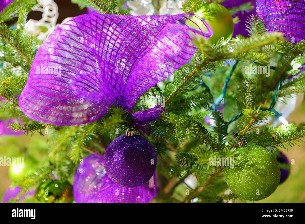 Close up of ornaments on a Christmas Tree with lights and other decorations. Stock Photo