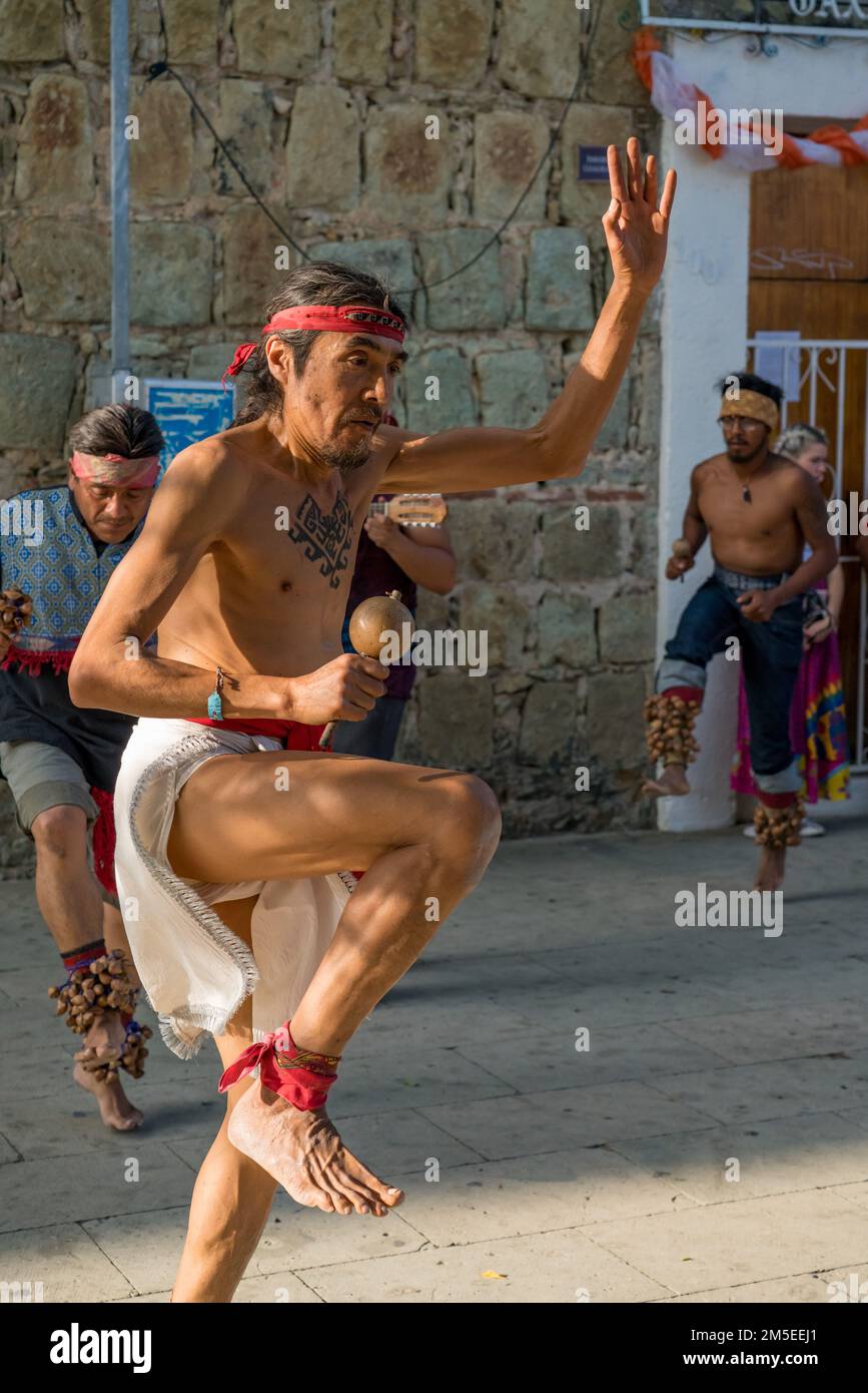 A tattooed Zapotec dancer in a loincloth dances in a plaza in Oaxaca