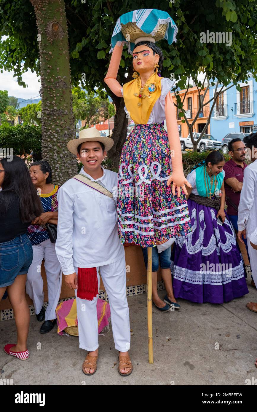 A farolero dancer with a giant puppet representing a canastera before a Guelaguetza festival parade in Oaxaca, Mexico. Stock Photo