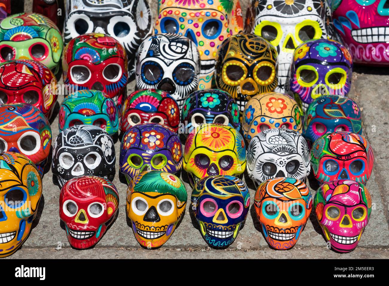 Colorful hand-painted ceramic skulls celebrating the Day of the Dead Fiesta for sale on the street in Oaxaca, Mexico. Stock Photo