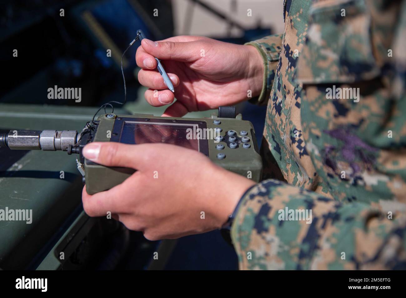 U.S. Marine Corps Lance Cpl. Marvin Diaz, a satellite communications operator with 9th Communication Battalion, I Marine Expeditionary Force Information Group, loads crypto on the PYQ-10 Simple Key Loader at Marine Corps Base Camp Pendleton, California, March 11, 2022. This training allows the 9th Communication Battalion to be capable of operating, defending, and preserving information networks to enable command and control for the commander in all domains, and support and conduct Marine Air Ground Task Force operations in the information environment. Stock Photo