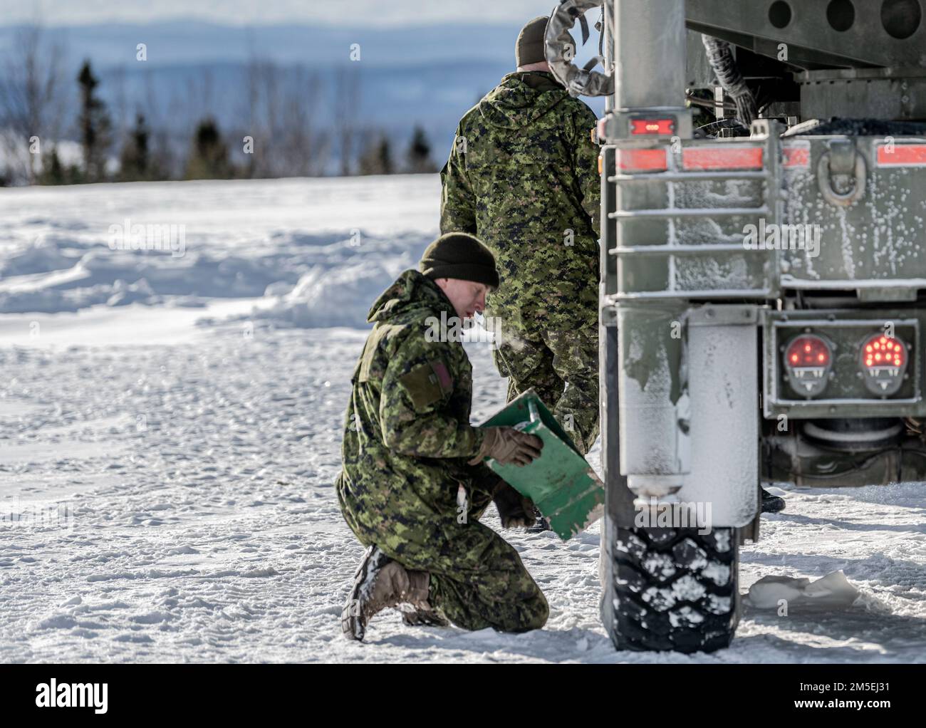 A Canadian Army Soldier with 4th Artillery Regiment puts a chock under