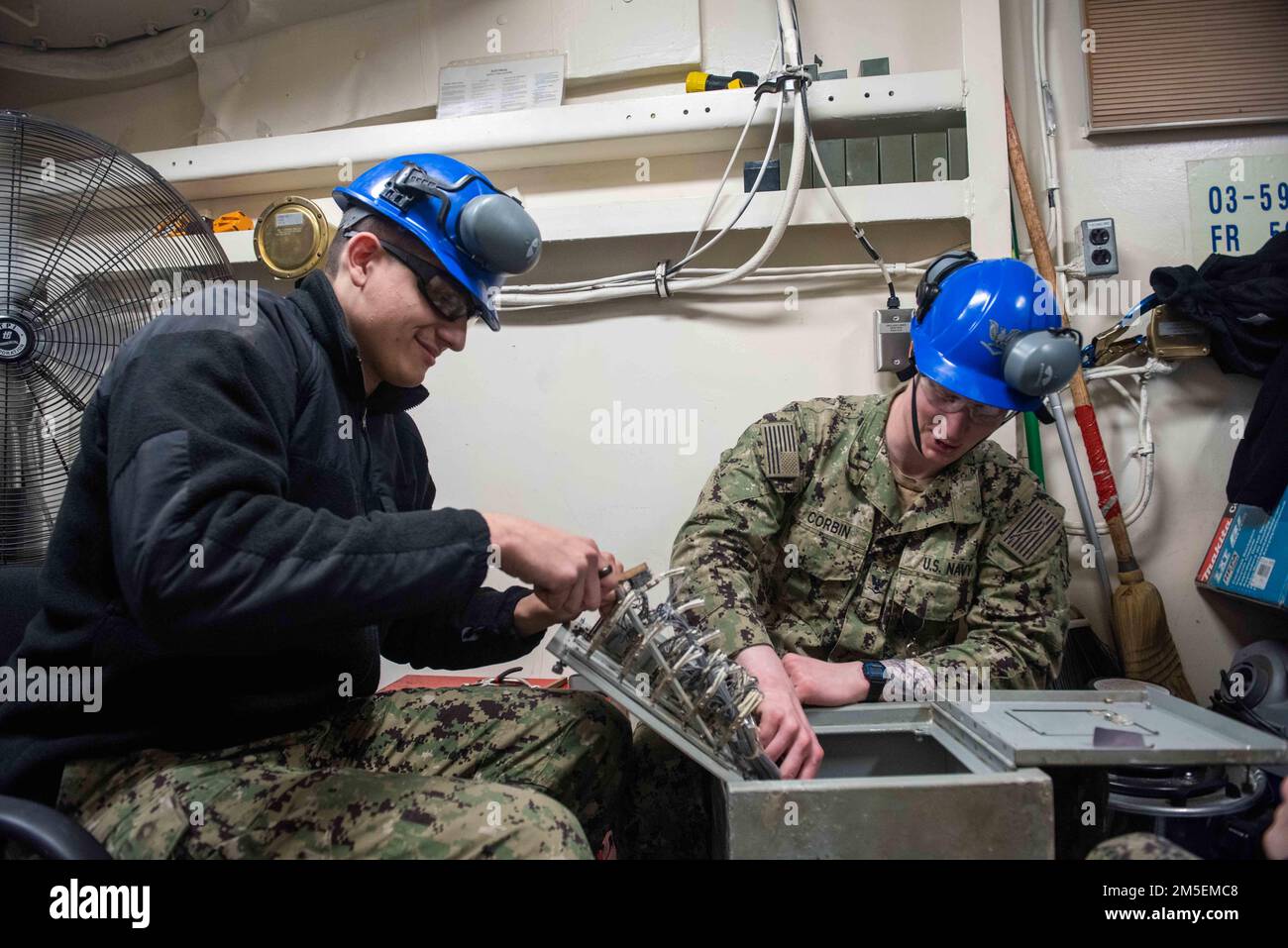 Interior Communications Electrician Seaman Nicholas Holmes, left, from Easton, Pennsylvania, and Interior Communications Electrician 3rd Class Jonathan Corbin, from Huntsville, Alabama, perform maintenance on a patch panel aboard the aircraft carrier USS John C. Stennis (CVN 74), in Newport News, Virginia, March 8, 2022. The John C. Stennis is in Newport News Shipyard  working alongside NNS, NAVSEA and contractors conducting Refueling and Complex Overhaul as part of the mission to deliver the warship back in the fight, on time and on budget, to resume its duty of defending the United States. Stock Photo