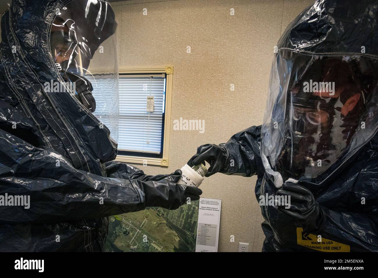U.S. Army Sgt. Eric Boyer, right, places evidence into a container held by Staff Sgt. Nicky Lam, both survey team members with the 21st Weapons of Mass Destruction-Civil Support Team (21st WMD-CST), New Jersey National Guard, at a simulated crime scene during an Army North training exercise at the William J. Hughes Technical Center, Federal Aviation Administration, Egg Harbor Township, New Jersey, March 3, 2022. The 21st identifies chemical, biological, radiological, and nuclear substances; assesses and advises civil authorities on response measures to man-made or natural disasters. (New Jerse Stock Photo