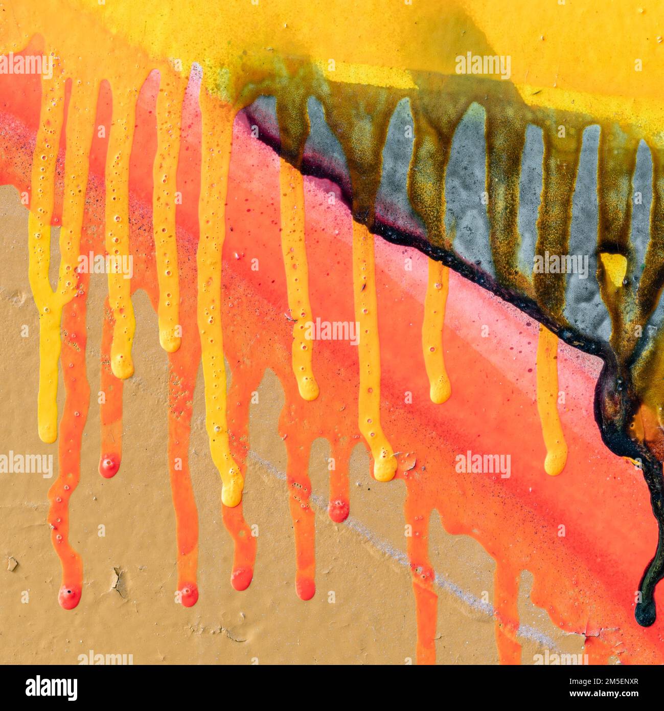 Square image of red and yellow paint runs against a grey background Stock Photo
