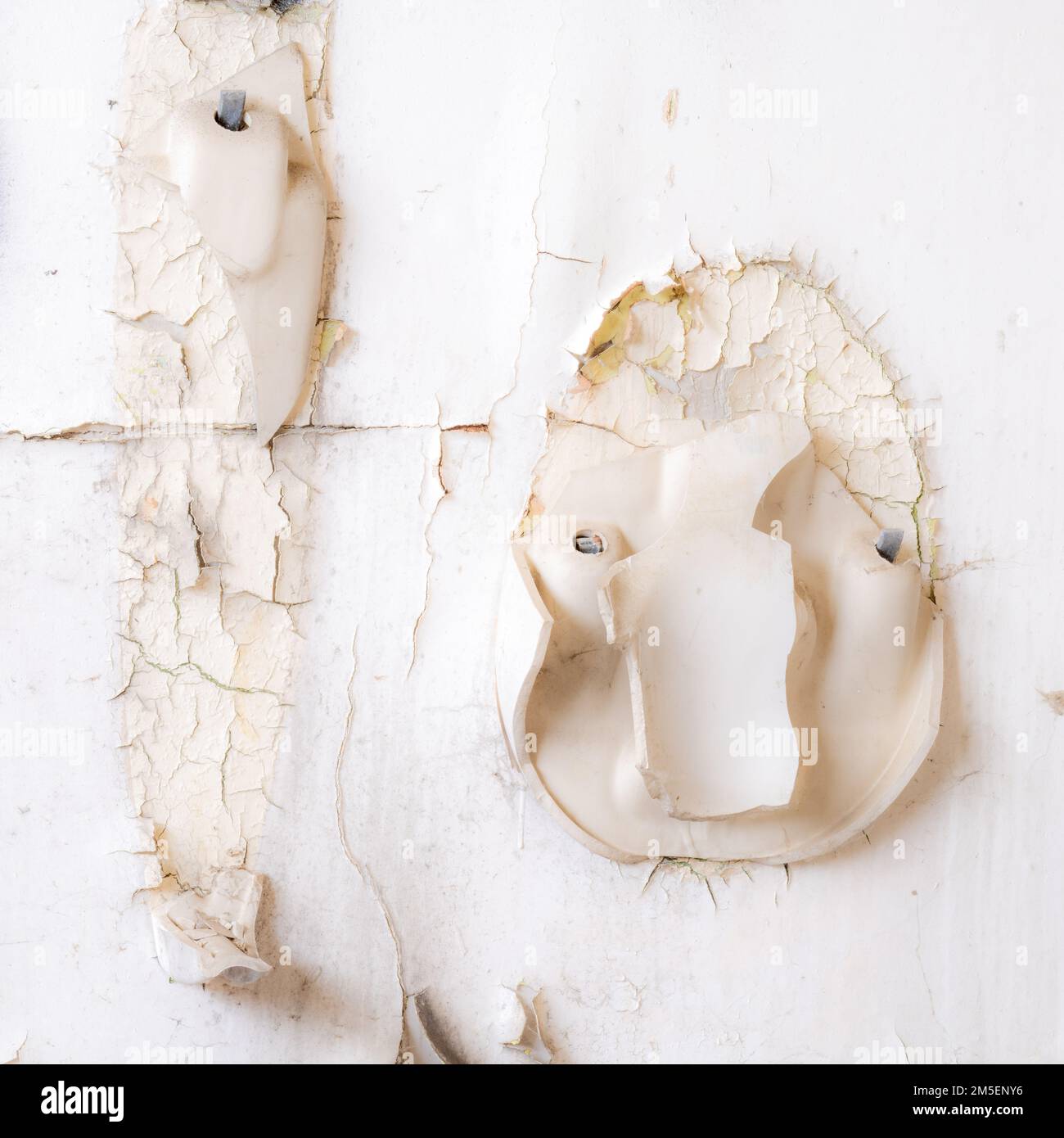 Square image of a broken urinal on a dilapidated wall Stock Photo