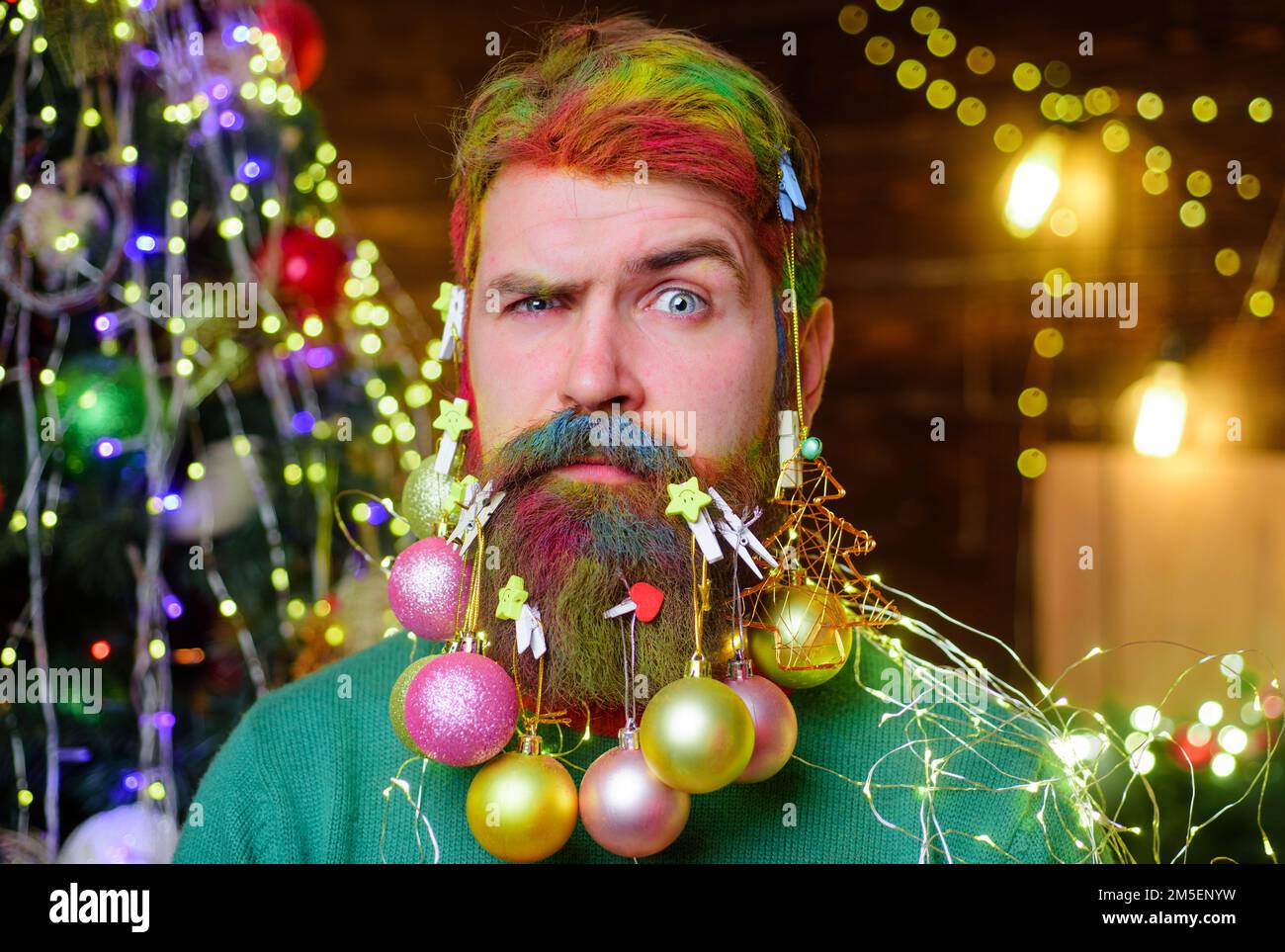 Serious bearded man with decorated beard. Christmas decoration. New year party. Holiday celebration. Stock Photo