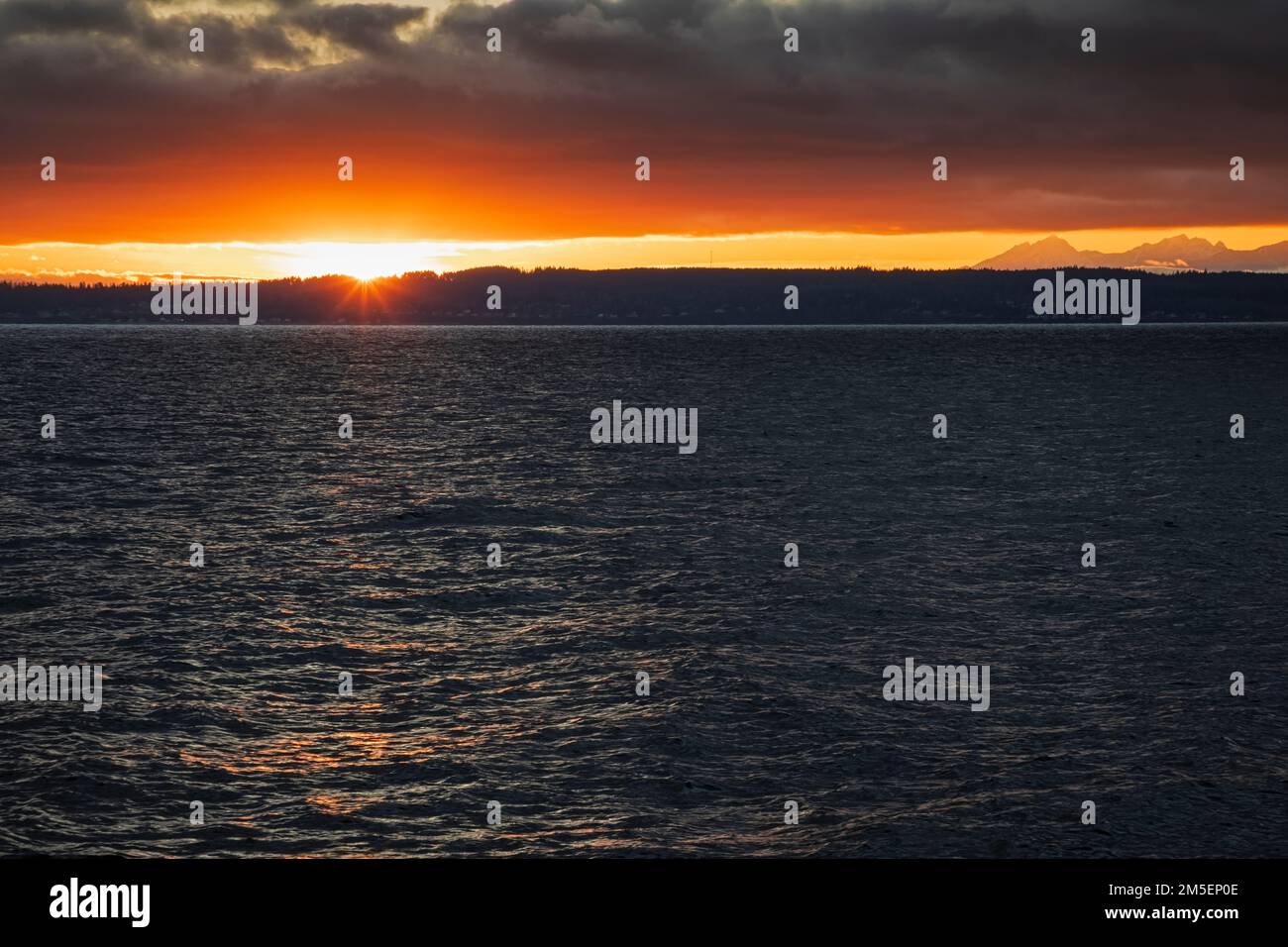 WA22894-00...WASHINGTON - Sunset setting over the Kitsap Peninsula and the Salish Sea/Puget Sound. Stock Photo