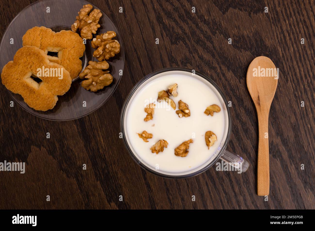 top view of  rice cookies, nuts and soy yogurt cup with spoon on dark wooden table, vegan food, gluten free Stock Photo