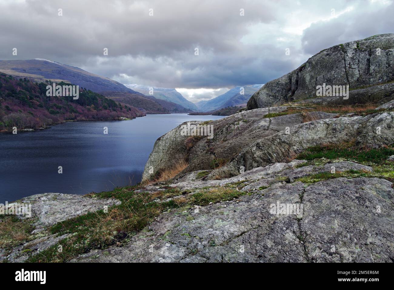 A view looking across Lake Padarn towards the Llanberis Pass from the rocky crag of Craig yr Undeb (Union Rock) in the Snowdonia National Park. Stock Photo