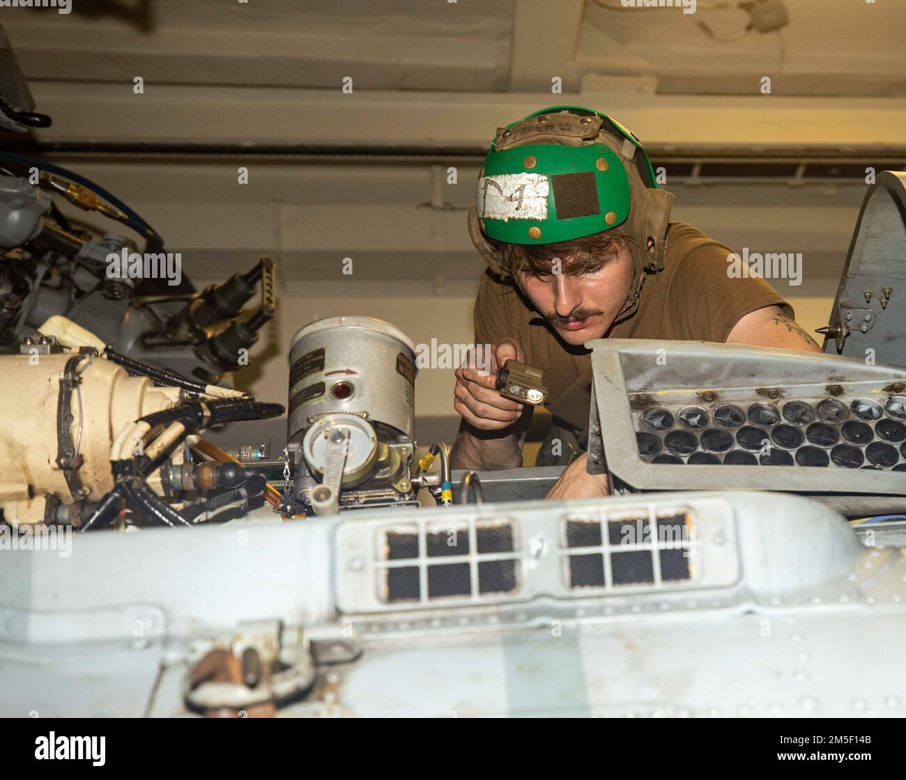 PHILIPPINE SEA (March 9, 2022) Aviation Structural Mechanic Airman Kyle Evers, from Jacksonville, Fl., conducts maintenance on an MH-60R helicopter aboard Arleigh Burke-class guided-missile destroyer USS Ralph Johnson (DDG 114). Ralph Johnson is assigned to Task Force 71/Destroyer Squadron (DESRON) 15, the Navy’s largest forward-deployed DESRON and the U.S. 7th fleet’s principal surface force. Stock Photo