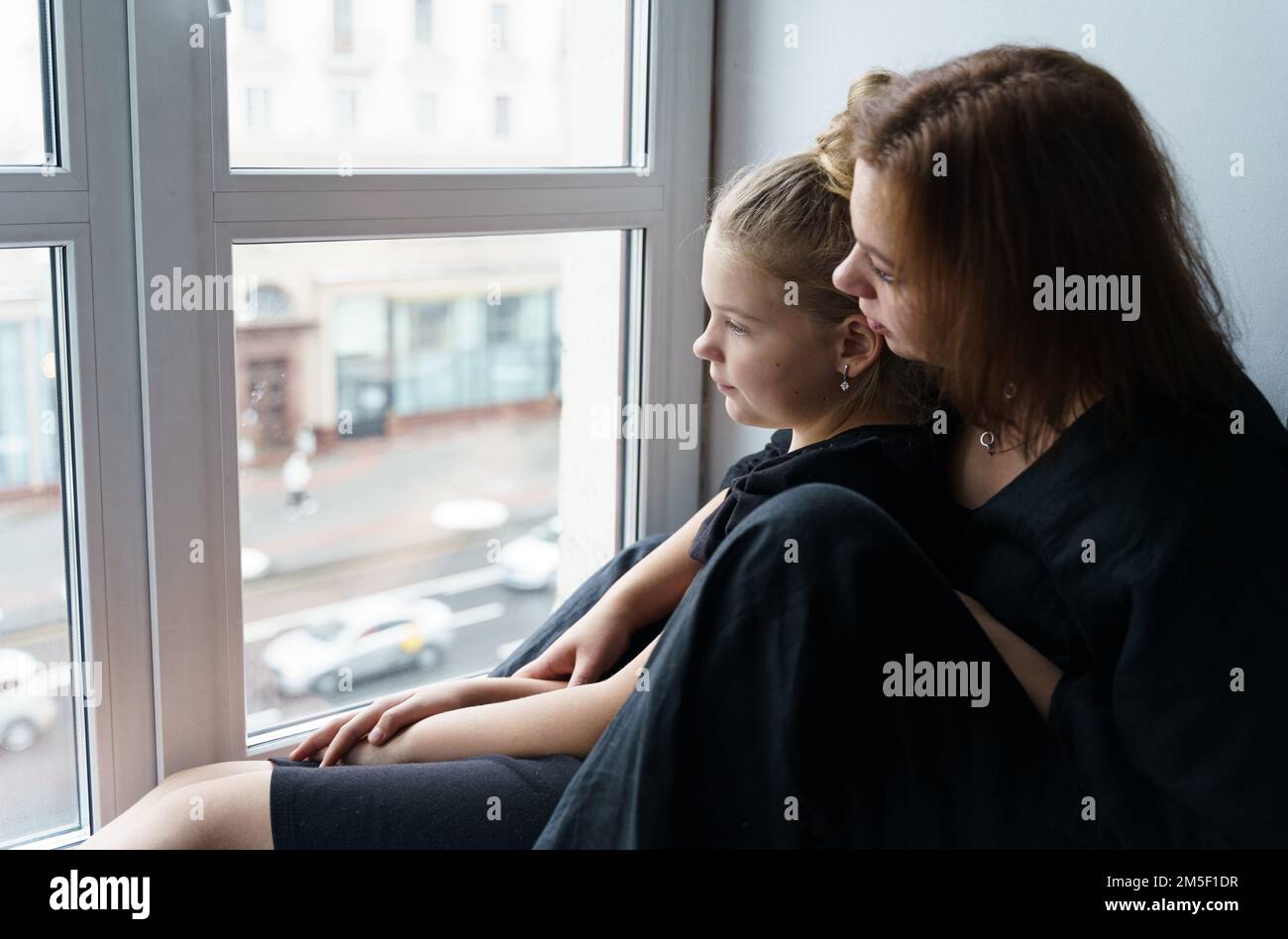Family concept. Mom hugs her teenage daughter, together they look out ...