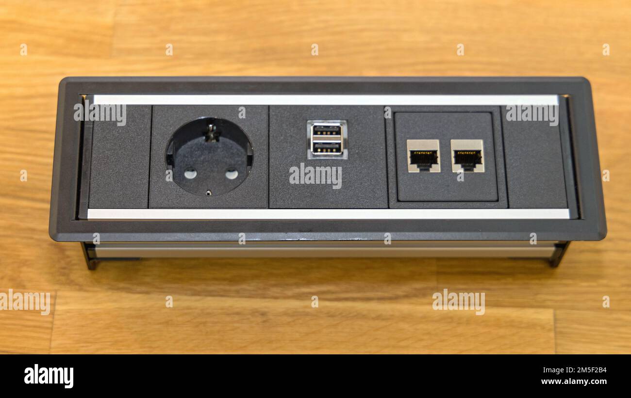Electric Outlet With Usb and Network Connections at Desk Stock Photo