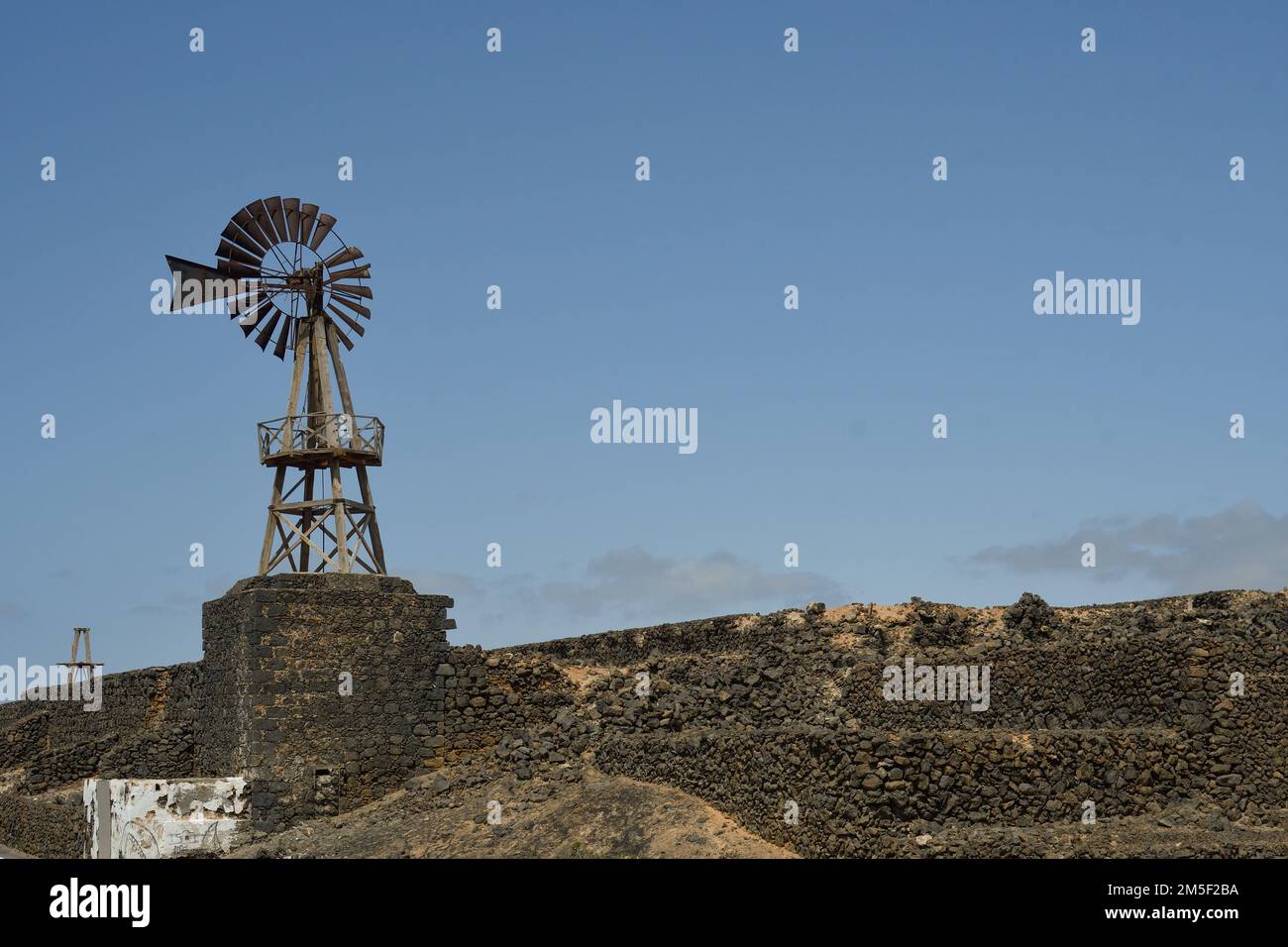 Old windmill on the volcanic lava next to the port of Arrecife in Lanzarote Stock Photo