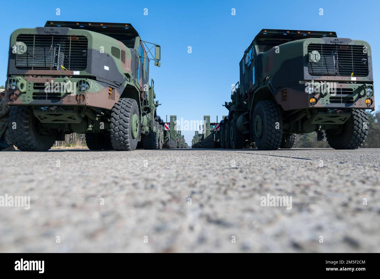 U.S. Army Enhanced Heavy Equipment Transporter Systems line up in a staging area, in the Army