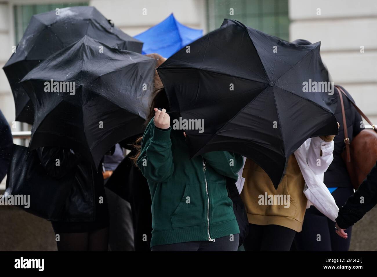 File photo dated 30/09/22 of people struggle with their umbrellas during the wet and windy weather in Birmingham. The deadly bomb cyclone that has sent temperatures plunging in the US is also causing the UK to experience wet and windy weather, the Met Office said. On Wednesday, the forecaster issued a yellow weather warning for heavy rain from 3am on Friday for 15 hours for much of Scotland, including Edinburgh, Glasgow and Stirling. Issue date: Wednesday December 28, 2022. Stock Photo