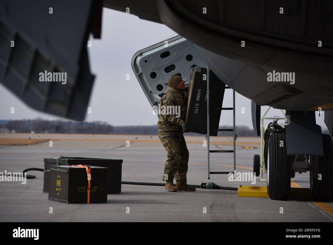An Iowa Air National Guard Airmen loads equipment through the crew hatch of a U.S. Air Force KC-135 tail number 57-2606 at the 185th Air Refueling Wing in Sioux City, Iowa on March 10, 2022. The aircraft is being prepared for departure to the Aerospace Maintenance and Regeneration Group or AMARG at Davis-Monthon Air Force Base where it will be retired.  U.S. Air National Guard photo Senior Master Sgt. Vincent De Groot 185th ARW Wing PA Stock Photo