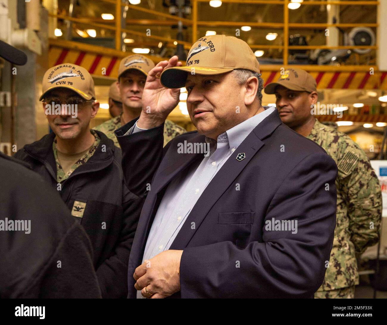 Secretary of the Navy Carlos Del Toro wears a USS Gerald R. Ford (CVN ...