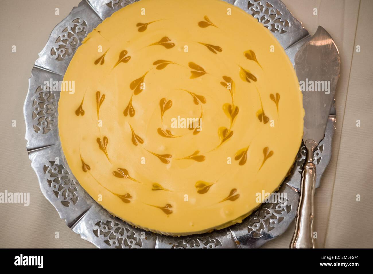 Beautiful mango cake with small mango heart decorations served on a silver tray. Stock Photo