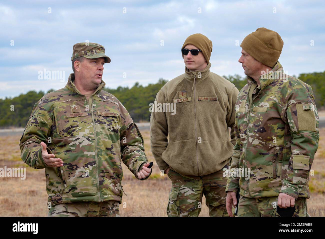 U.S. Air Force Brig. Gen. Patrick M. Kennedy, Assistant Adjutant General-Air, New Jersey National Guard, left, 2d Lt. Daniel J. Walker, New Jersey Joint Force Headquarters executive officer, center, and Master Sgt. Matthew D. Dever, Warren Grove Range non-commissioned officer in charge of communications, discuss decommissioned military vehicles repurposed for target practice March 10, 2022, at the Warren Grove Gunnery Range, Warren Grove, New Jersey. Kennedy and Chief Master Sgt. Michael J. Rakauckas, New Jersey Air National Guard state command chief, took a tour of the Warren Grove Gunnery Ra Stock Photo