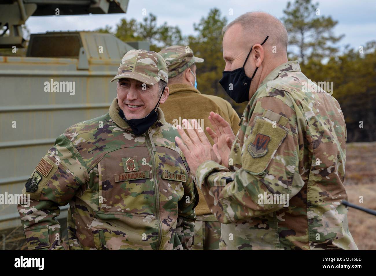U.S. Air Force Chief Master Sgt. Michael J. Rakauckas, New Jersey Air National Guard state command chief, left, discusses decommissioned military vehicles repurposed for target practice with Master Sgt. Steven Gaskill, Warren Grove Range superintendent, right, March 10, 2022, at the Warren Grove Gunnery Range, Warren Grove, New Jersey. Brig. Gen. Patrick M. Kennedy, Assistant Adjutant General-Air, New Jersey National Guard, and Rakauckas took a tour of the Warren Grove Gunnery Range and observed A-10 Thunderbolt IIs training during their visit. Stock Photo