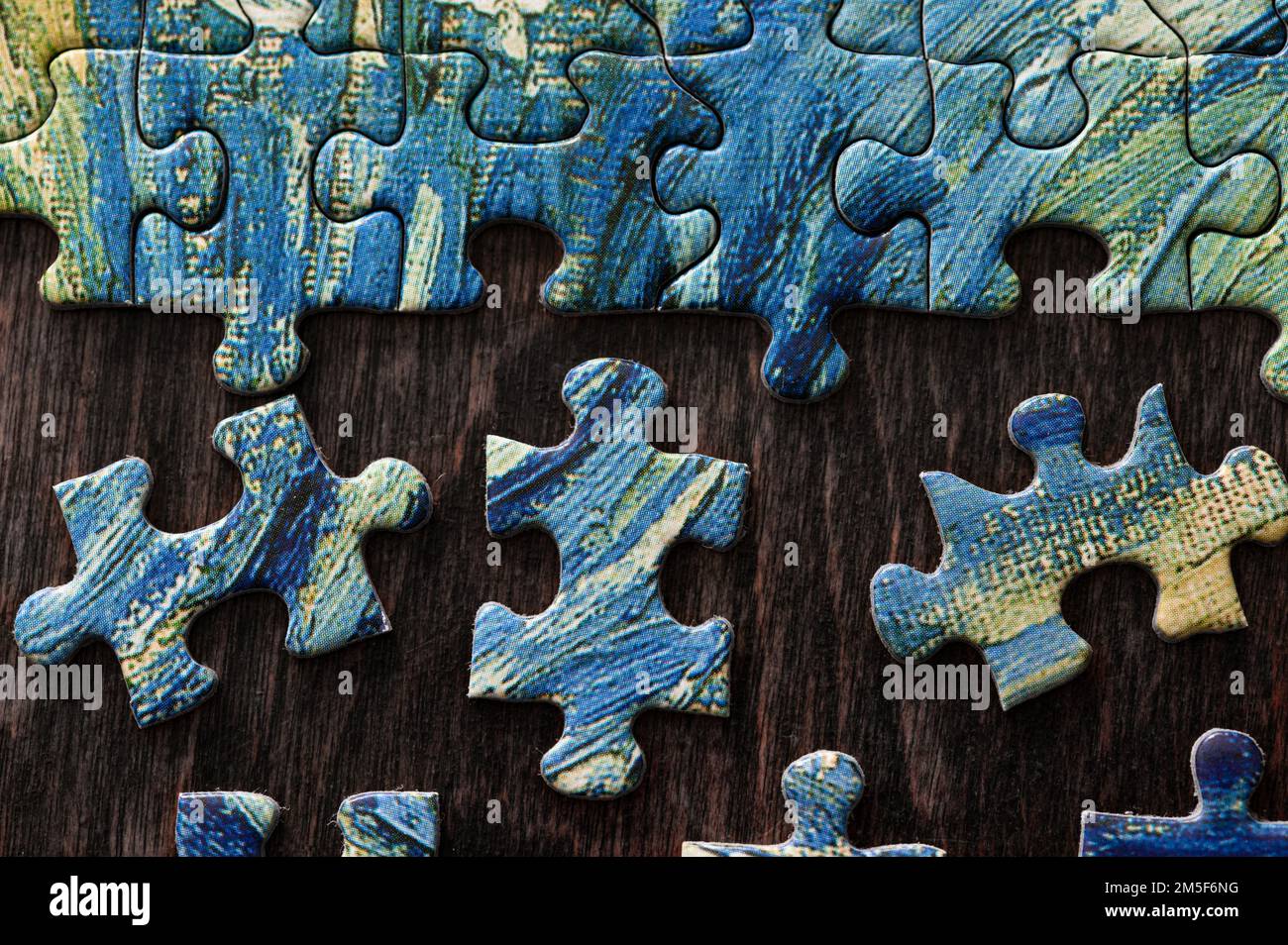 Blue and yellow puzzle being put together Stock Photo