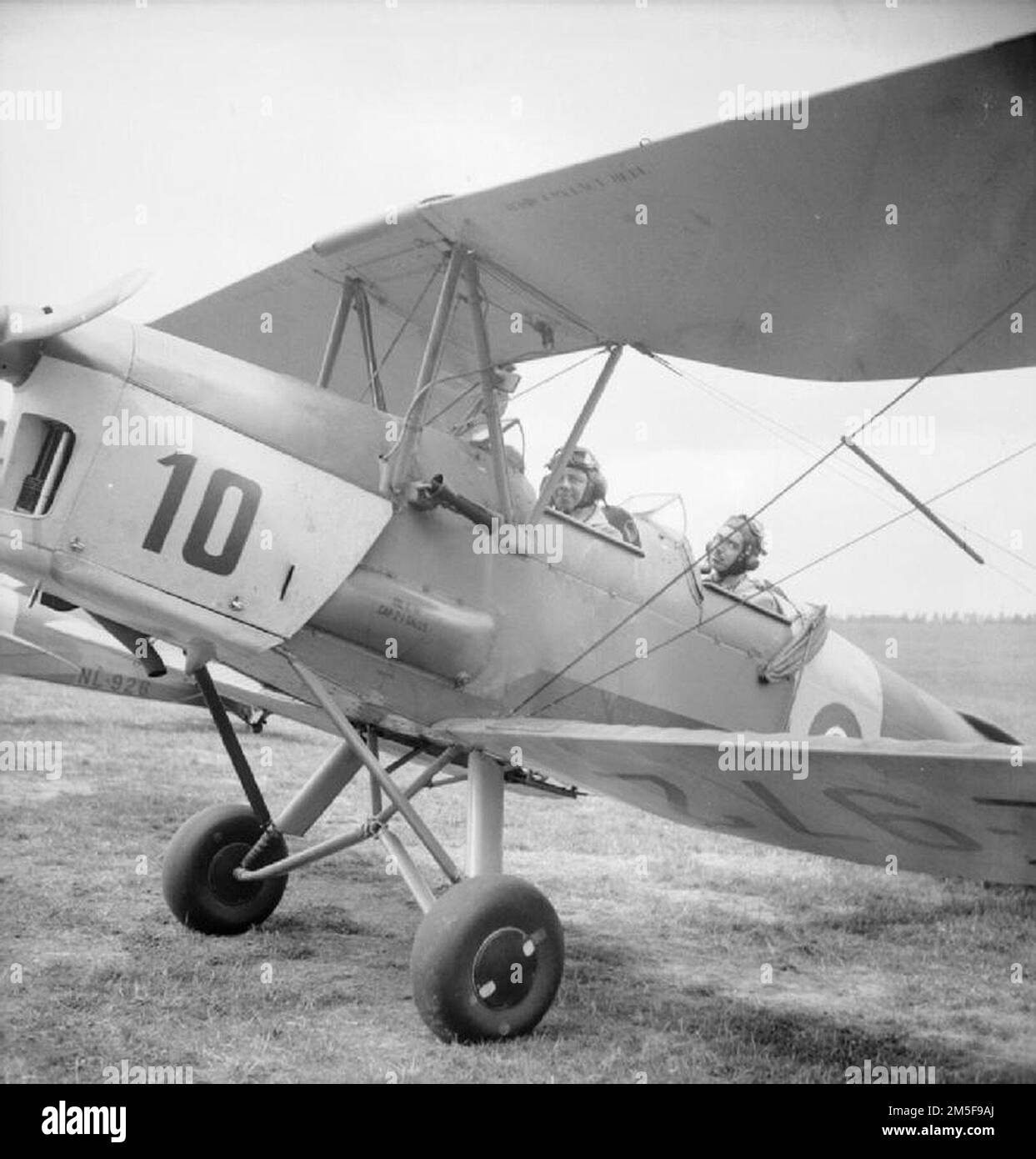 A pupil and instructor sit in a dual-control Tiger Moth aircraft at the Belgian Air Training School at Snailwell, near Newmarket Stock Photo