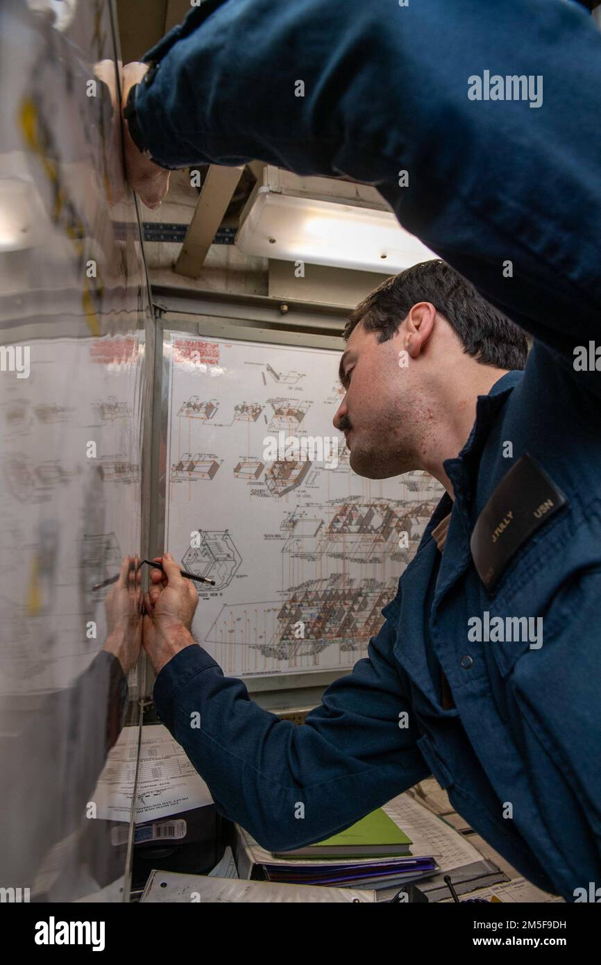 220310-N-HG846-1012 IONIAN SEA (March 10, 2022) – Ensign James Tully, from Long Island, N.Y., marks reported notes on a ship diagram during a firefighting drill aboard Arleigh Burke-class guided-missile destroyer USS Mitscher (DDG 57), March 10, 2022. Mitscher is currently deployed with the Harry S. Truman Carrier Strike Group in the U.S. Sixth Fleet area of operations in support of U.S., allied and partner interests in Europe and Africa. Stock Photo