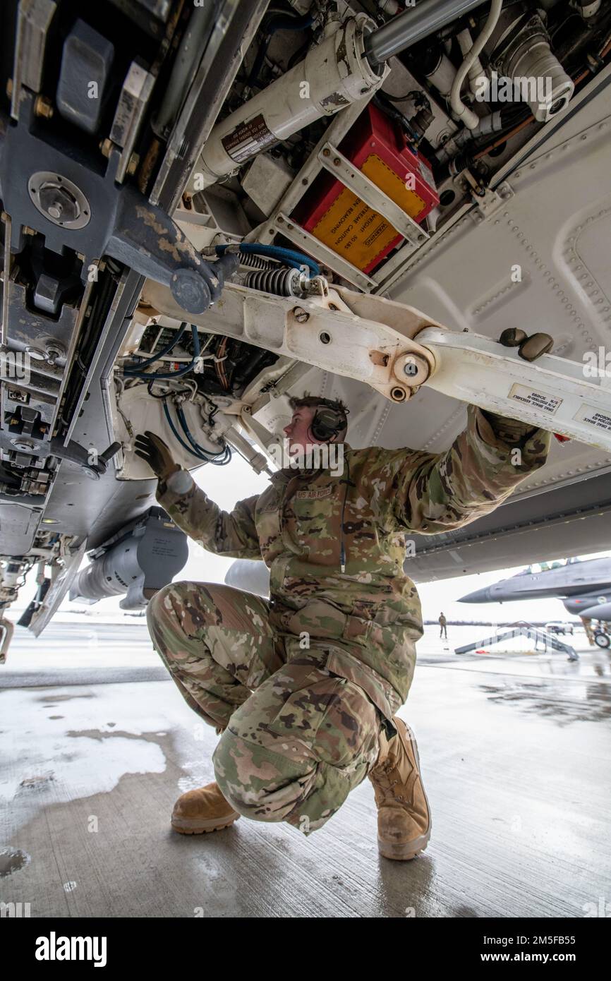 U.S. Air Force Staff Sgt. Noah LeStrange, a crew chief assigned to Ohio National Guard’s 180th Fighter Wing, inspects the underside of an F-16 Fighting Falcon, assigned to the 180FW, prior to launch during U.S. Northern Command Exercise ARCTIC EDGE 2022 at Joint Base Elmendorf-Richardson, Alaska, March 11, 2022.  AE22 is a biennial defense exercise for U.S. Northern Command and Canadian Armed Forces to demonstrate and exercise a joint capability to rapidly deploy and operate in the Arctic. Stock Photo