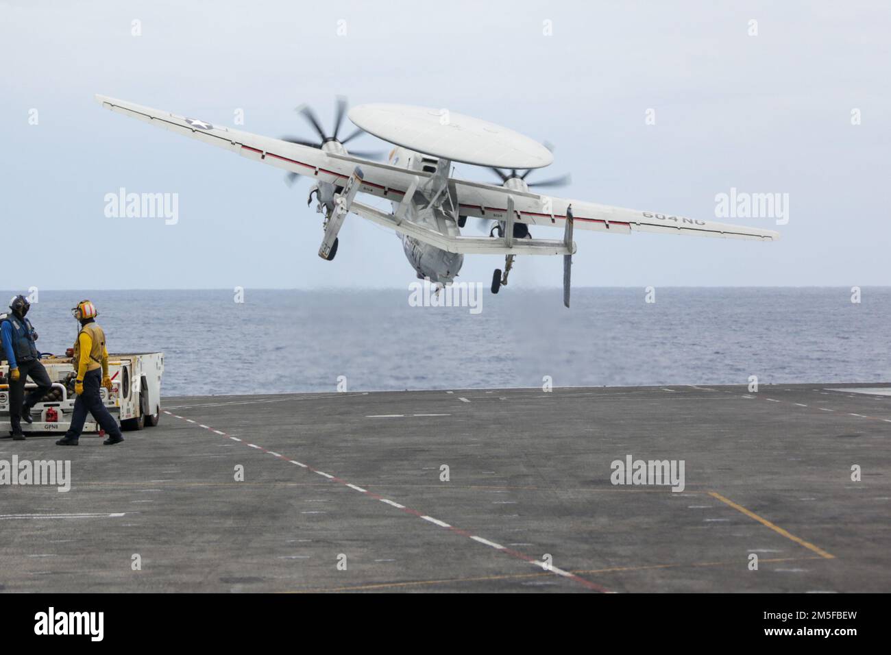 PHILIPPINE SEA (March 11, 2022) An E-2D Hawkeye, assigned to the “Wallbangers” of Carrier Airborne Early Warning Squadron (VAW) 117, launches from the flight deck of the Nimitz-class aircraft carrier USS Abraham Lincoln (CVN 72). Abraham Lincoln Strike Group is on a scheduled deployment in the U.S. 7th Fleet area of operations to enhance interoperability through alliances and partnerships while serving as a ready-response force in support of a free and open Indo-Pacific region. Stock Photo