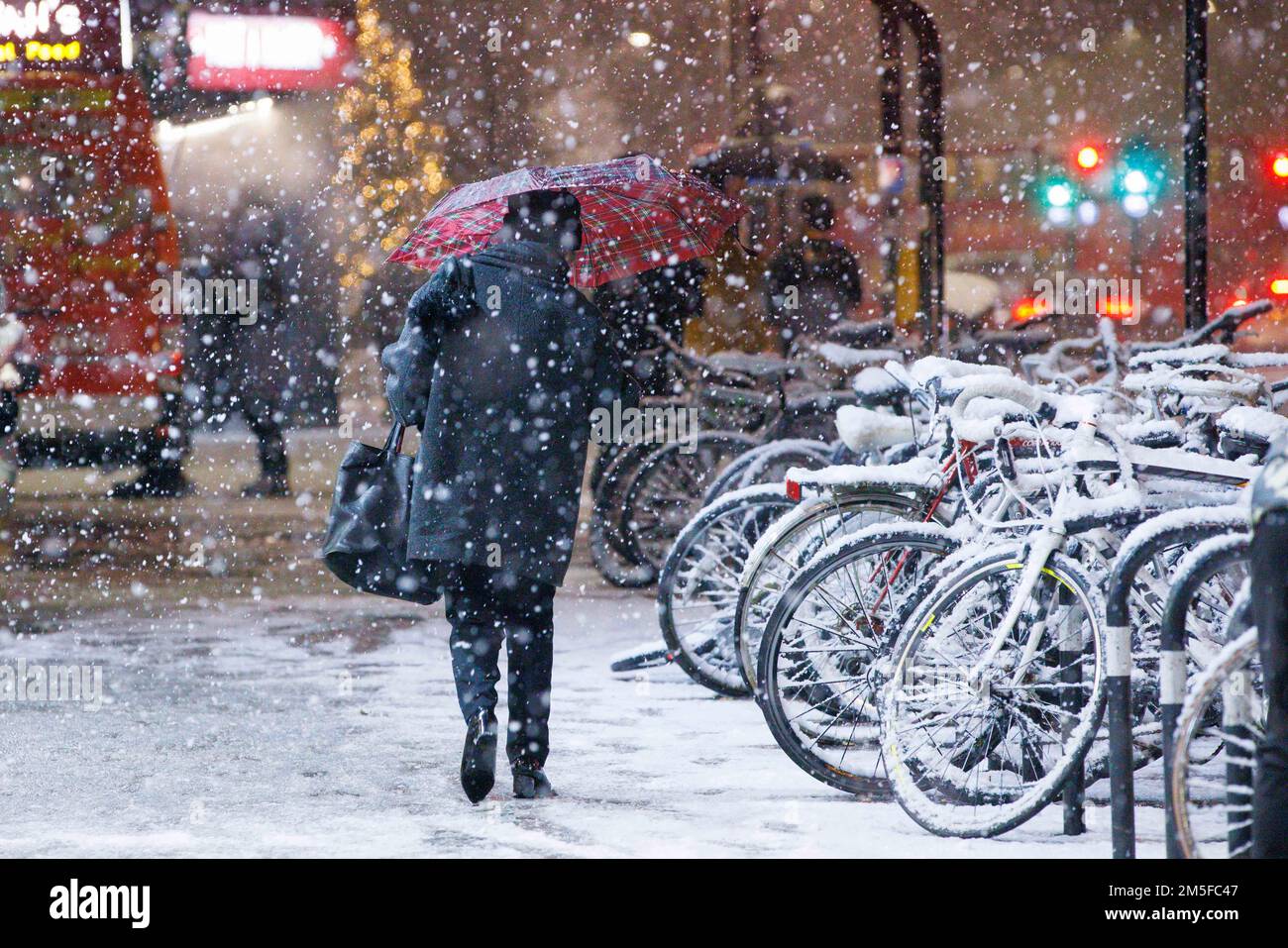 Snow falls on bicycles in Stockwell, South West London, as an un-forecast cold snap covers the capital and much of the south east of England with a bl Stock Photo