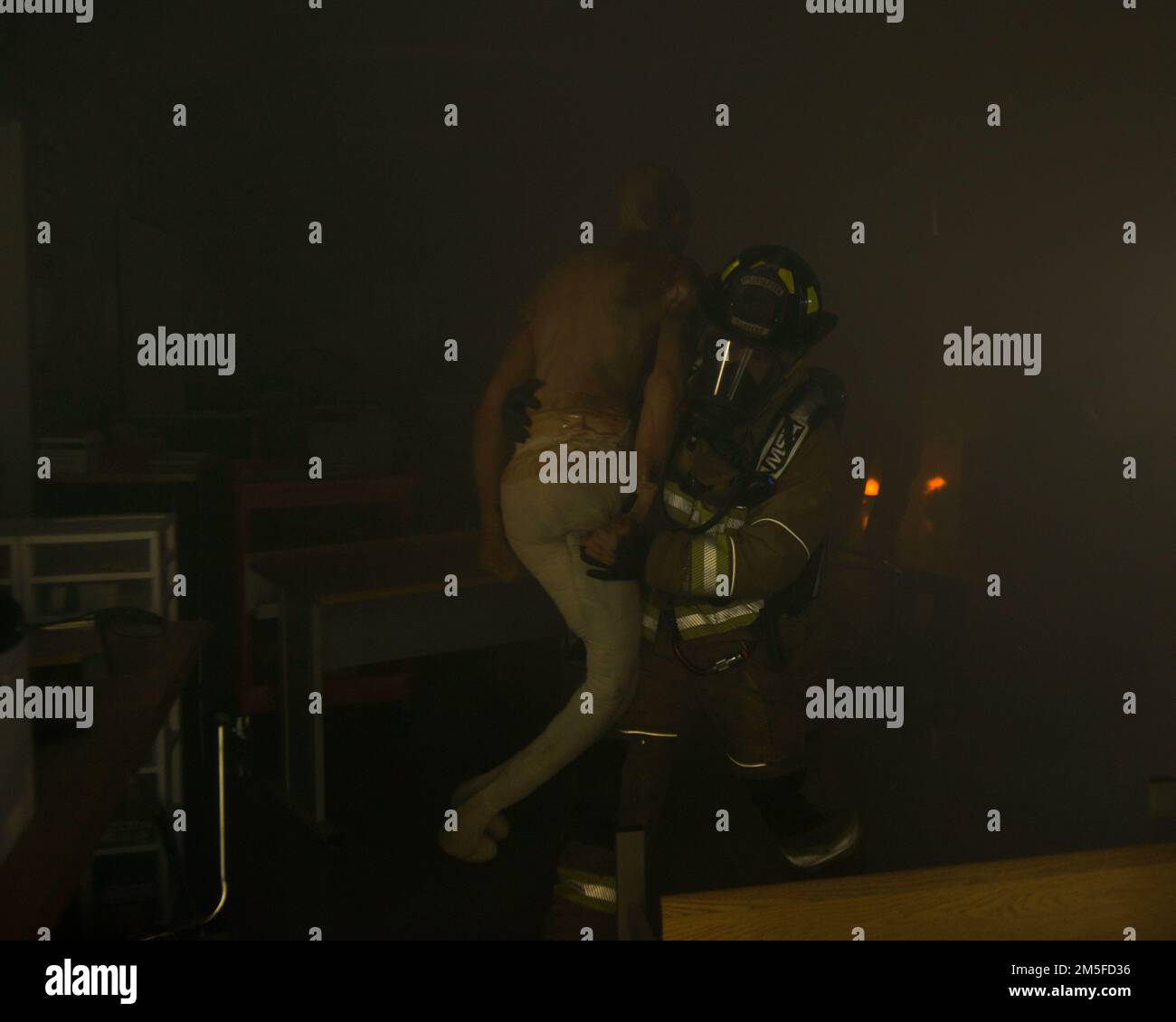 A firefighter with the Minot Fire Department carries a dummy out of a