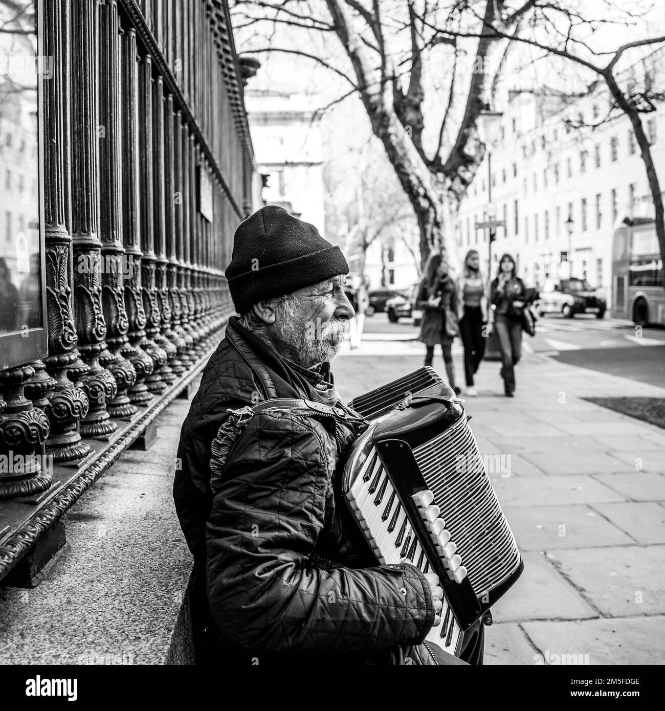 Accordion player busking in the street. London UK. Black & white with