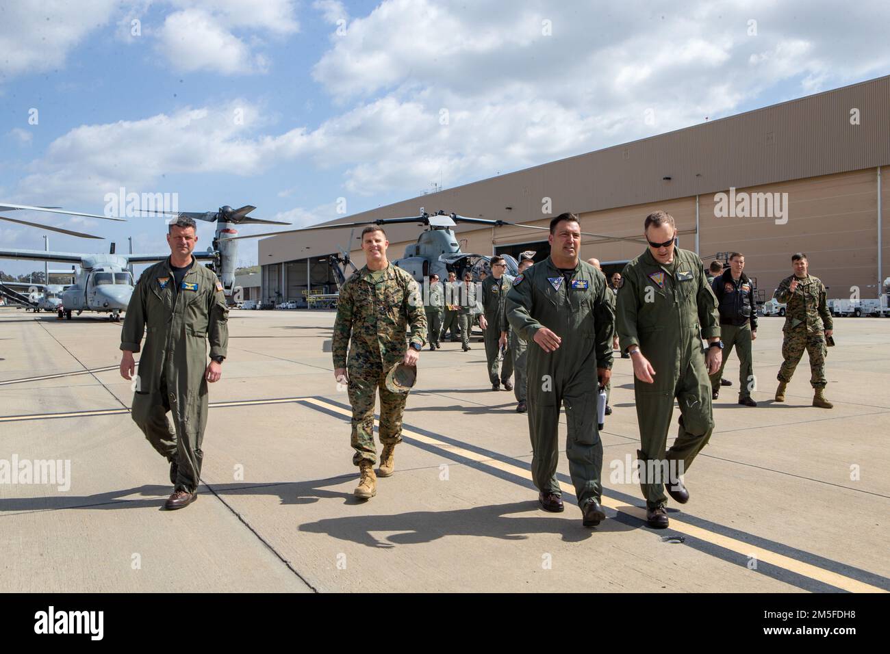 U.S. Marine Corps Col. David B. Moore, center-left, commanding officer, Marine Corps Air Station (MCAS) Camp Pendleton, and Col. Nathan S. Marvel, right, commanding officer, Marine Aircraft Group 39, 3rd Marine Aircraft Wing, and U.S. Navy Capt. Brannon Bickel, center-right, commodore, Helicopter Maritime Strike Wing (HSM) Pacific, and Capt. Edward Weiler, left, commodore, Helicopter Sea Combat Wing (HSC) Pacific, walk together at MCAS Camp Pendleton, California, March 10, 2022. Marines met with the commodores of HSM and HSC to discuss enhanced interoperability between Marine and Naval rotary Stock Photo