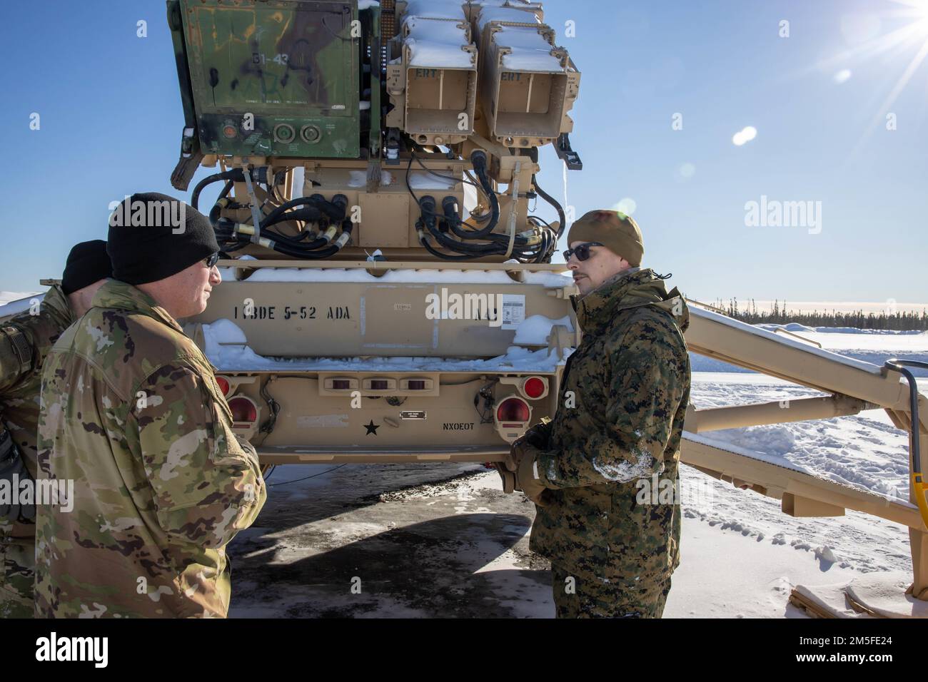 U.S. Navy Hospital Corpsman 2nd Class Giuseppe Anile, 2nd Landing Support Battalion, and Sergeant 1st Class Robert Dingle, a Patriot master gunner with 5th Battalion, 52nd Air Defense Artillery Regiment, discuss safety and health measures for use of the M903 Patriot Launcher during Exercise ARCTIC EDGE 2022, at Mullins Point on Eielson Air Force Base, Alaska, March 11, 2022. ARCTIC EDGE is a joint exercise designed to demonstrate our ability to rapidly deploy and operate in the Arctic. Stock Photo
