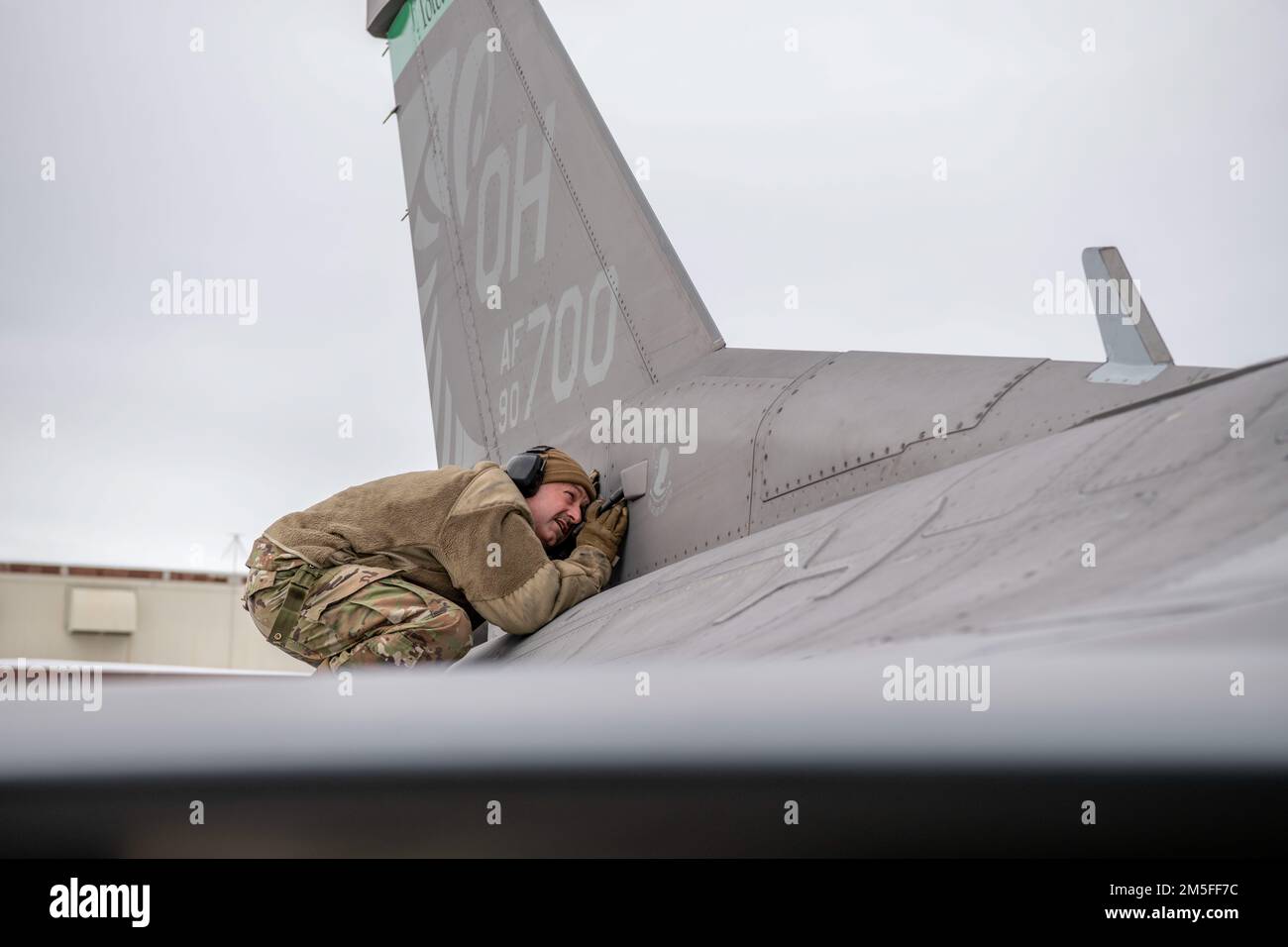 U.S. Air Force Master Sgt. Nate Phillips, an aircraft electrical and environmental systems specialist assigned to the Ohio National Guard’s 180th Fighter Wing, inspects the anti-collision light electrical systems on an F-16 Fighting Falcon, assigned to the 180FW, at Joint Base Elmendorf-Richardson, Alaska, during U.S. Northern Command Exercise ARCTIC EDGE 2022, March 11, 2022. AE22 is a biennial homeland defense exercise designed for U.S. and Canadian Armed Forces to demonstrate and exercise a joint capability to rapidly deploy and operate in the Arctic. Stock Photo