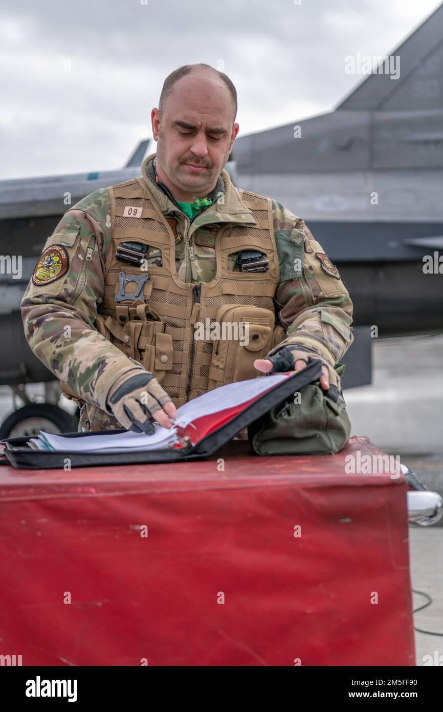 U.S. Air Force Maj. Elliot England, an F-16 fighter pilot assigned to the Ohio National Guard’s 180th Fighter Wing, conducts a pre-flight check before a training flight at Joint Base Elmendorf-Richardson, Alaska, during U.S. Northern Command Exercise ARCTIC EDGE 2022, March 11, 2022. AE22 is a biennial homeland defense exercise designed for U.S. and Canadian Armed Forces to demonstrate and exercise a joint capability to rapidly deploy and operate in the Arctic. Stock Photo