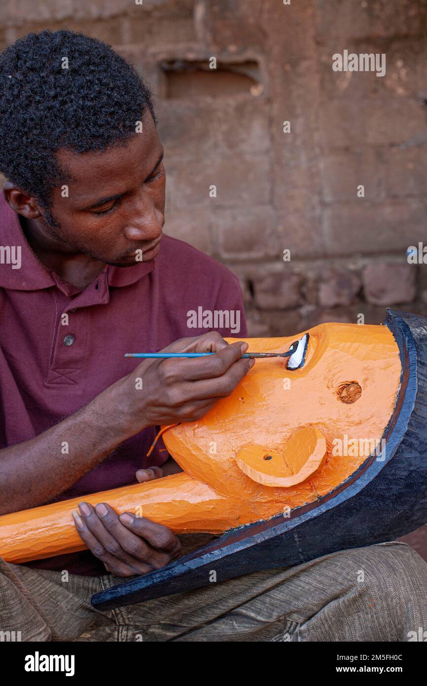 puppet maker is painting the face of a puppet in his ,Bamako