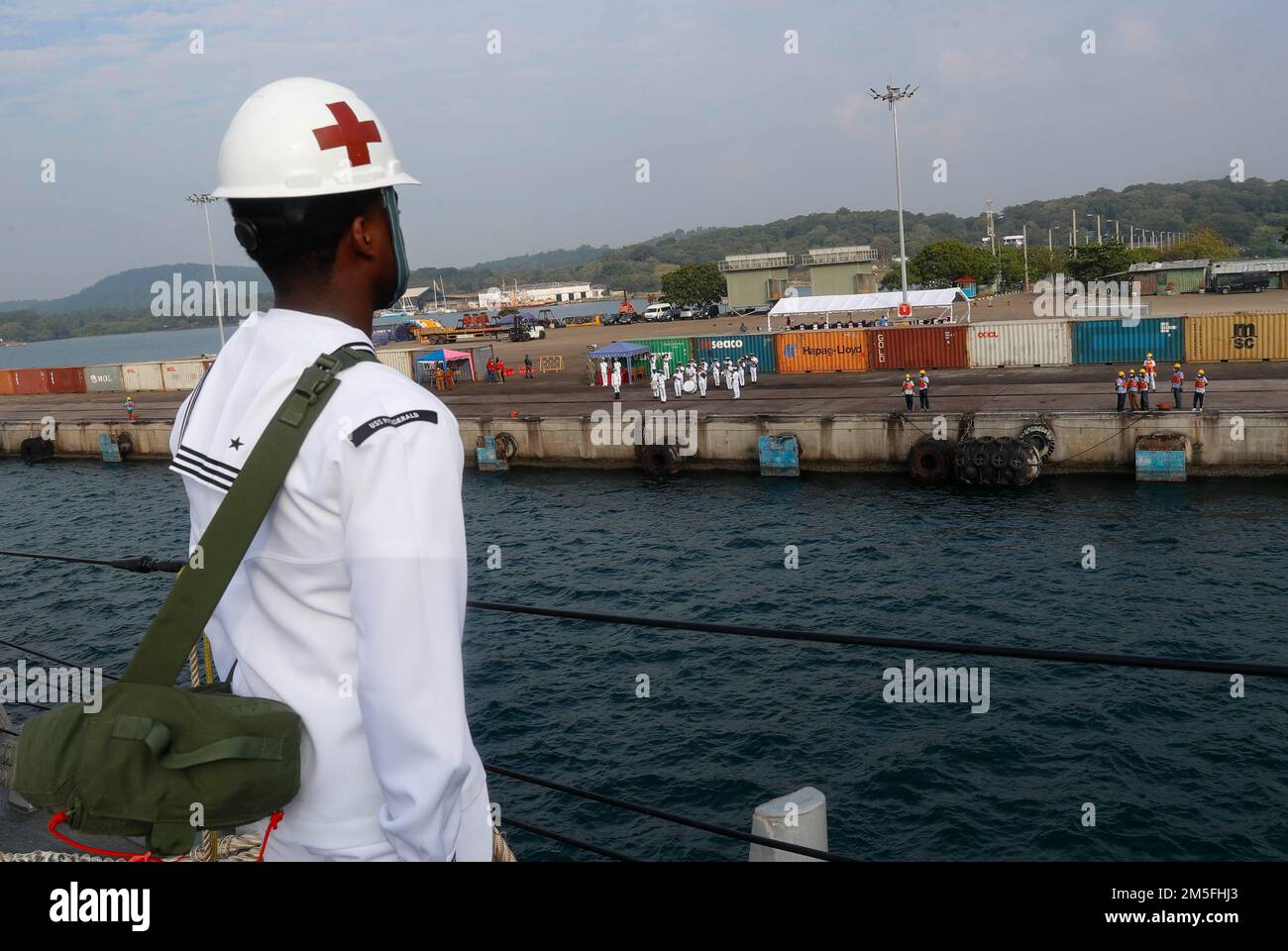 TRINCOMALEE, SRI LANKA (March 13, 2022) Hospital Corpsman 2nd Class David Worrell, from Jacksonville, Fla., mans the rails on the foc’sle of the Arleigh Burke-class guided-missile destroyer USS Fitzgerald (DDG 62) while the Sri Lankan Navy band plays on the pier. Fitzgerald is on a scheduled deployment in the U.S. 7th Fleet area of operations to enhance interoperability with alliances and partnerships while serving as a ready-response force in support of a free and open Indo-Pacific region. Stock Photo