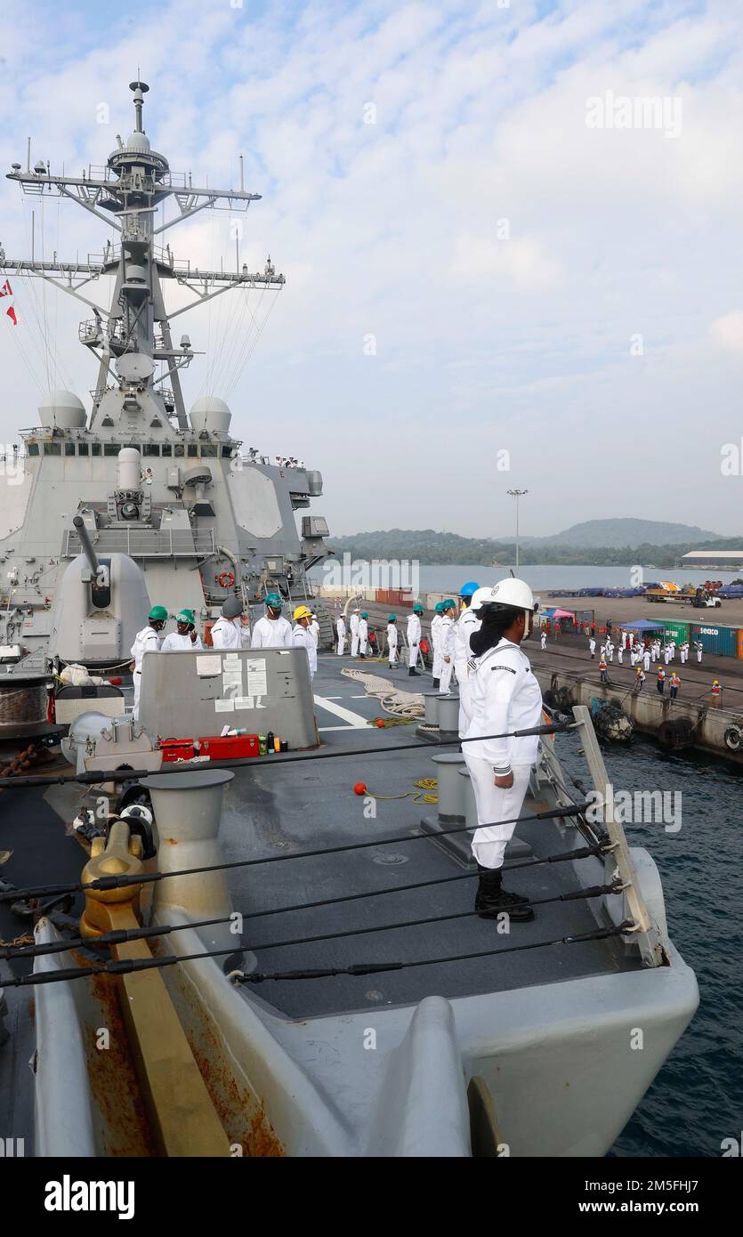 TRINCOMALEE, SRI LANKA (March 13, 2022) Sailors man the rails on the foc’sle of the Arleigh Burke-class guided-missile destroyer USS Fitzgerald (DDG 62) while the Sri Lankan Navy band plays on the pier. Fitzgerald is on a scheduled deployment in the U.S. 7th Fleet area of operations to enhance interoperability with alliances and partnerships while serving as a ready-response force in support of a free and open Indo-Pacific region. Stock Photo