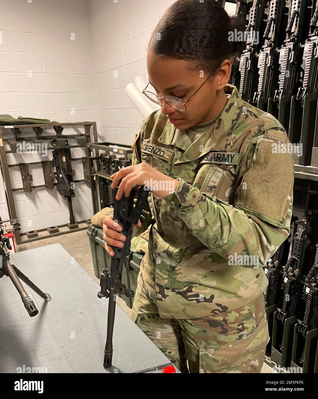 Pfc. Melody Lorenzo, a brand new Soldier with B Company, 328th Brigade Support Battalion, 56th Stryker Brigade Combat Team, 28th Infantry Division, supports her company in performing checks and inspections on M249 squad automatic weapons during drill weekend. The Soldiers from the company checked their equipment in preparation for the battalion to travel to Fort Pickett, Va., for future training. Stock Photo